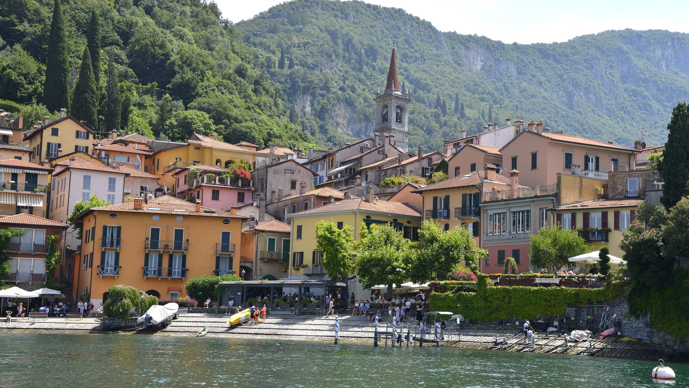 Varenna seen from the water: pastel houses and the church bell tower stacked above the lakeside promenade