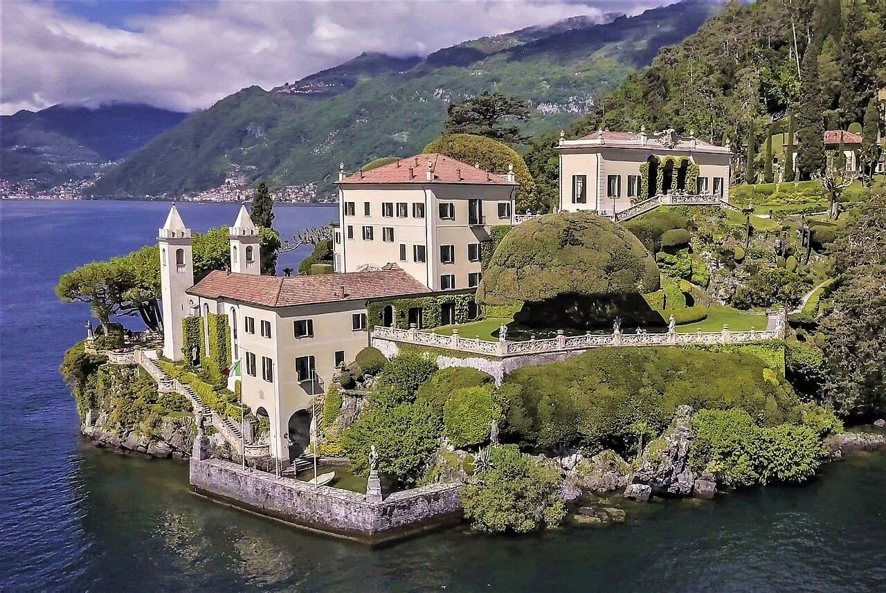 Private Cranchi boat cruising past Villa del Balbianello on Lake Como with guests enjoying aperitivo aboard